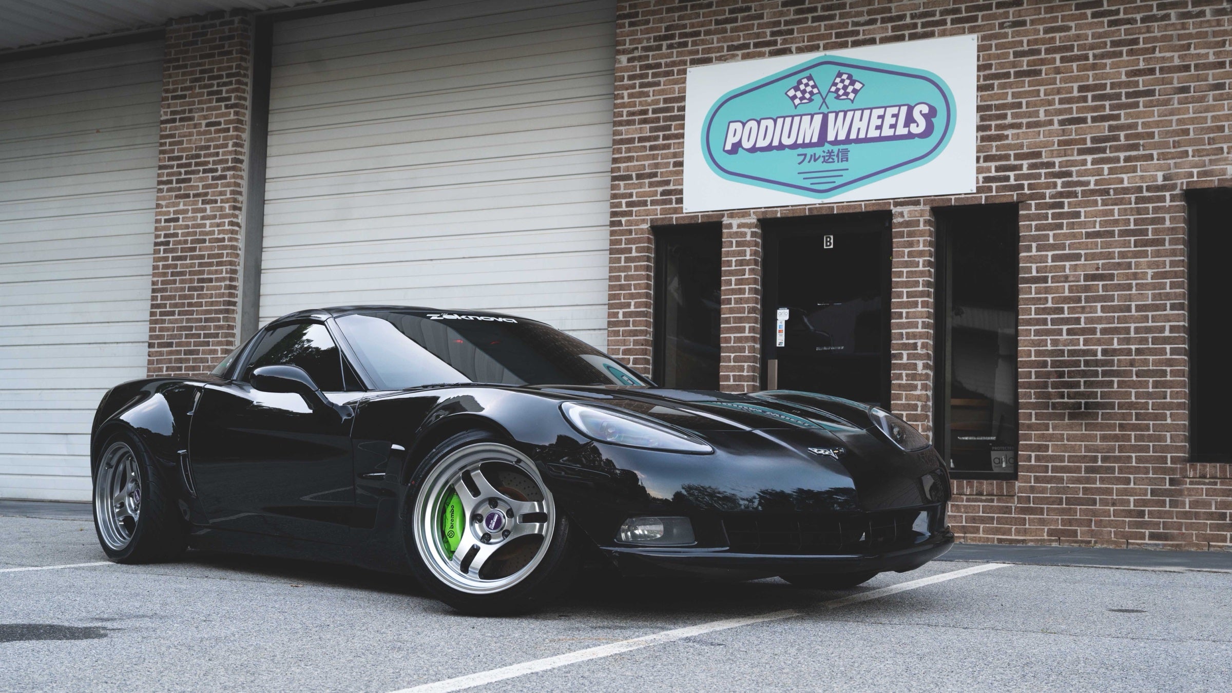 Black Corvette on Podium FF3 tri-spoke wheels outside the shop