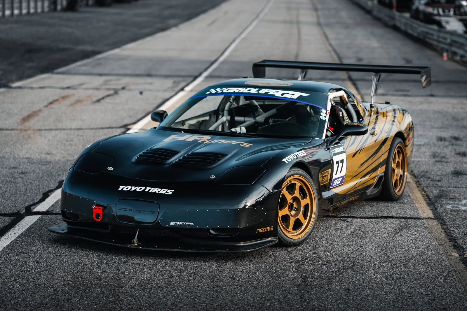Number 77 Corvette wearing gold six-spoke FF6 wheels in the paddock